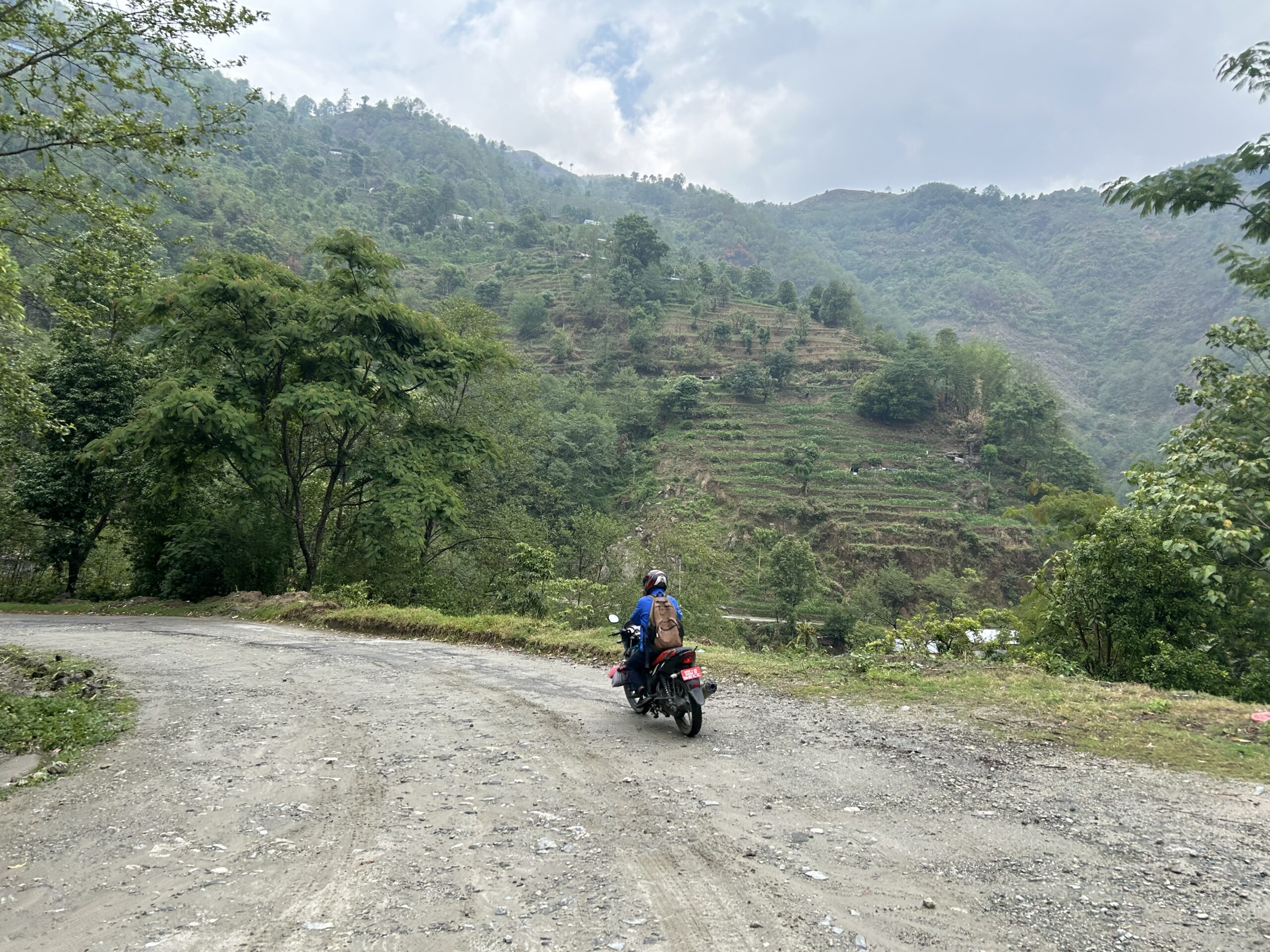 A motorbike rider on a hillside road in Nepal